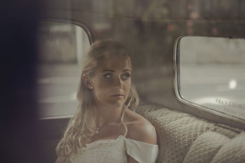 bride sitting in car before wedding