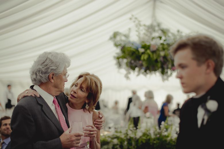 two wedding guests talking to one another