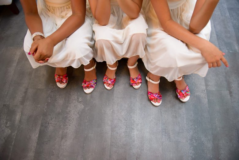 three flowers girls in white dresses and colorful shoes