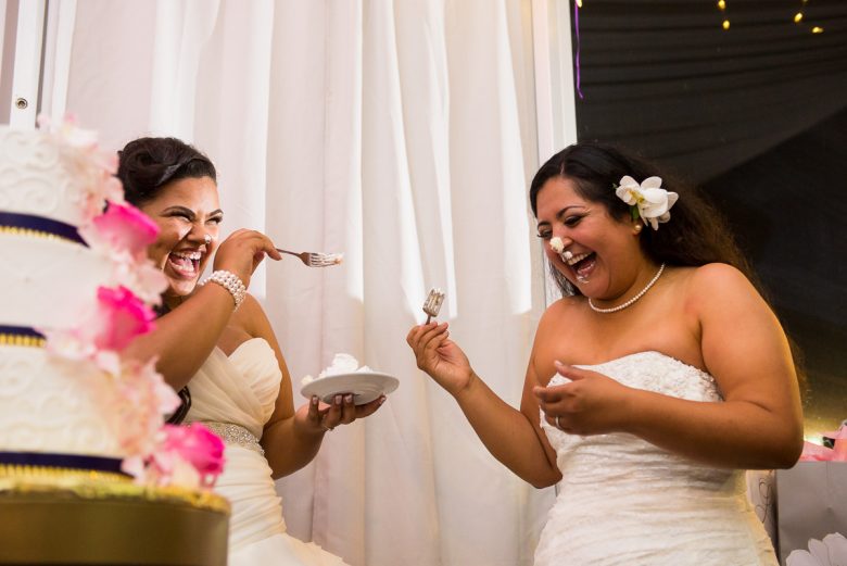 two brides smashing cake