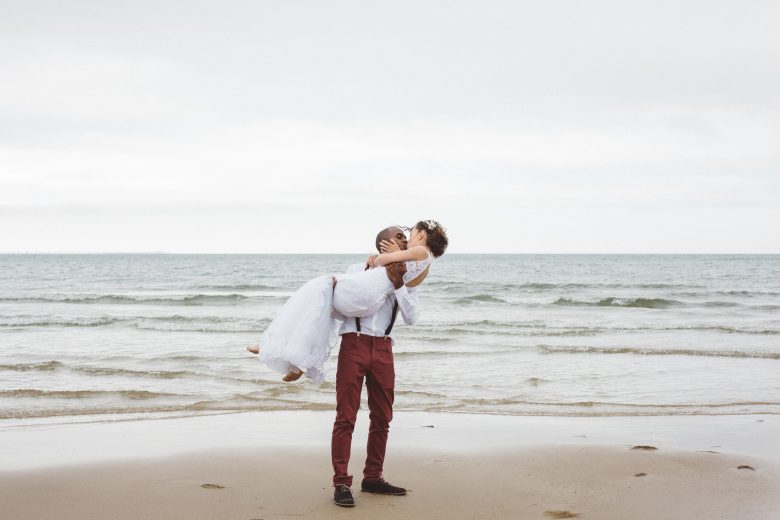 bride and groom with suspenders on the beach