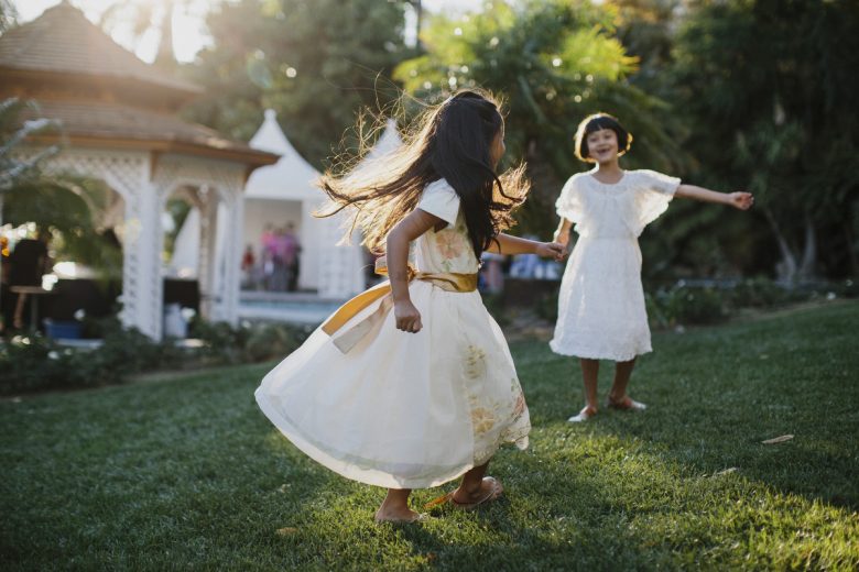 two girls playing outside at a wedding