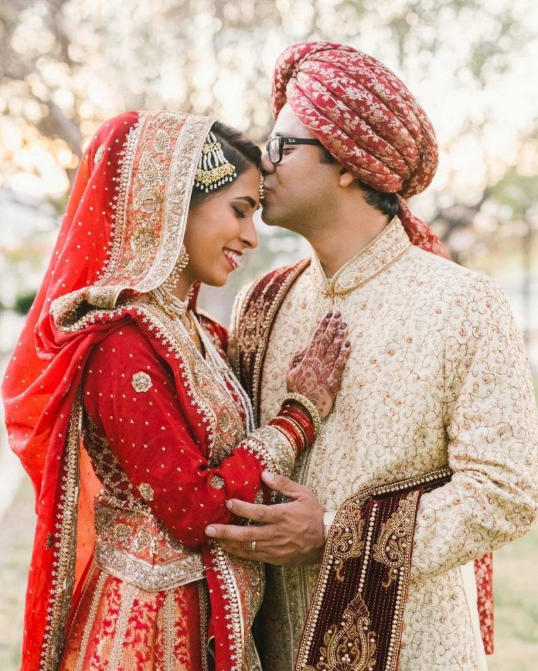 indian wedding groom kissing brides forhead