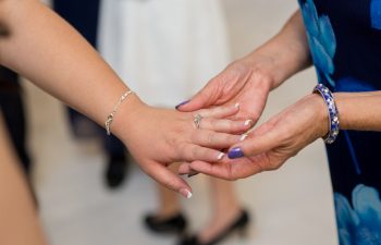 woman holding engaged woman's hand