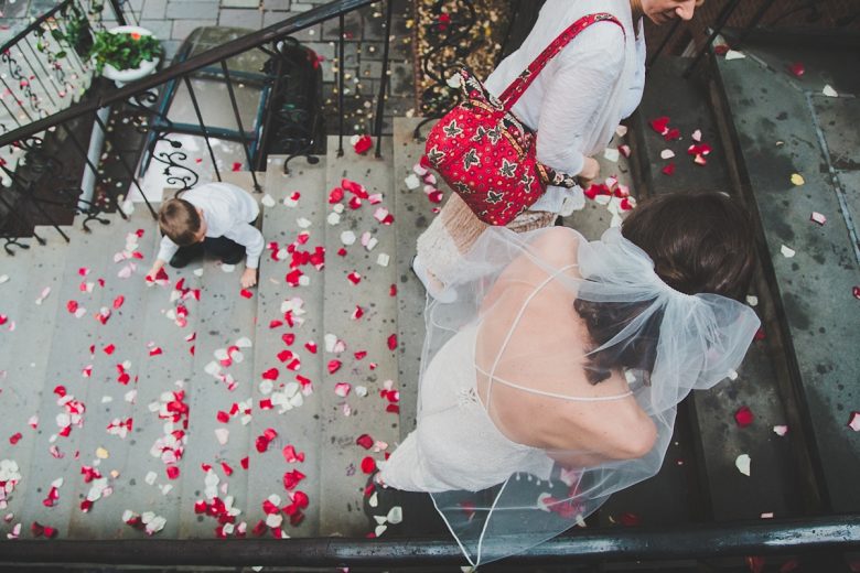 bride walking up staircase covered in rose petals