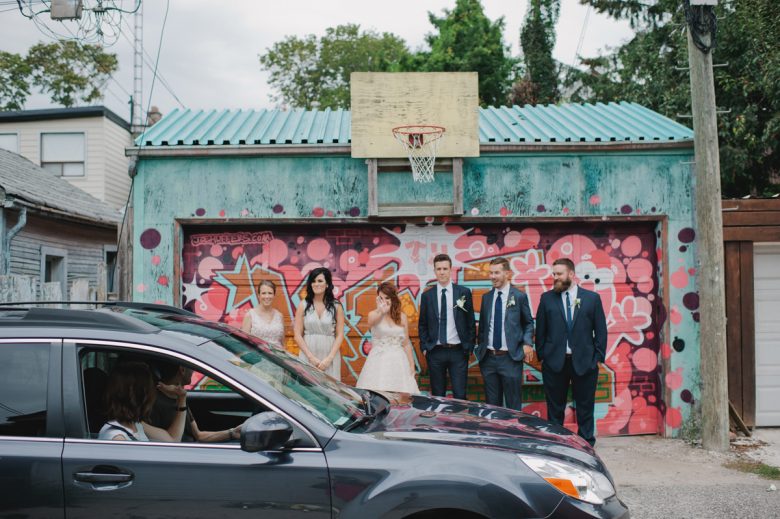 wedding party standing in front of colorful garage