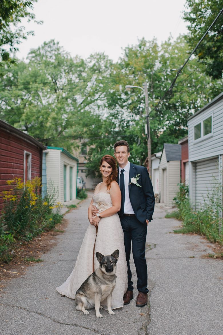 bride and groom standing with their dog