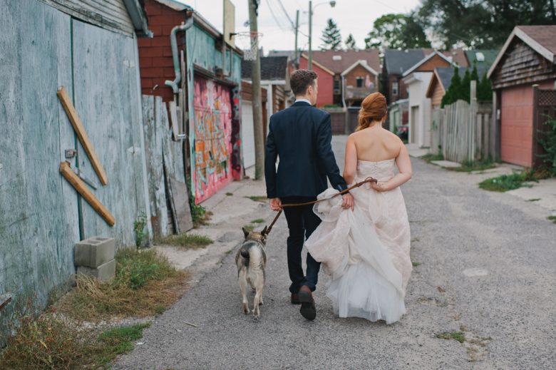 bride and groom walking with dog
