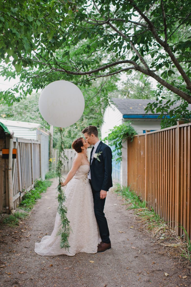 bride and groom standing with balloon