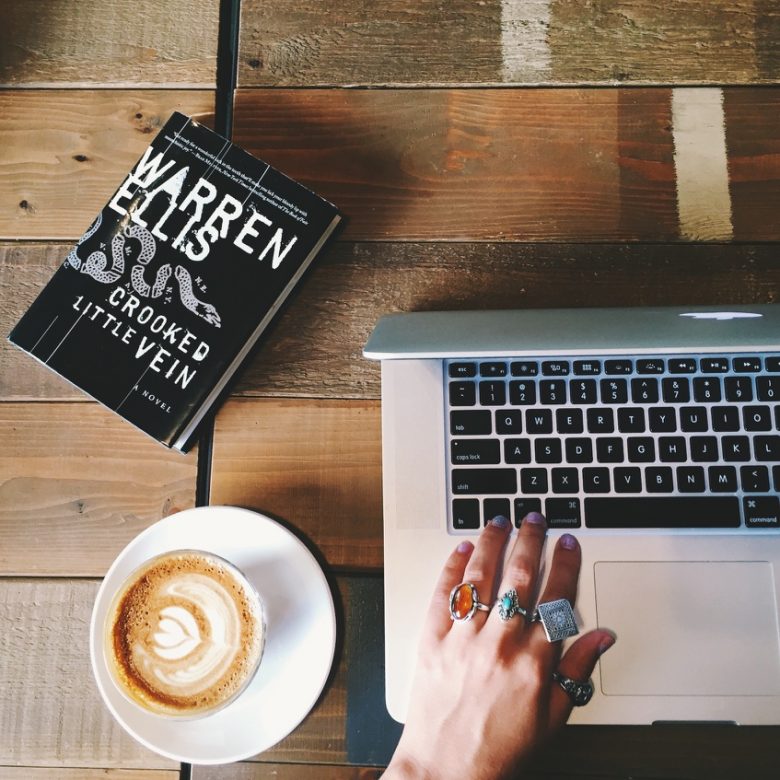 photo of woman with keyboard, book, and coffee