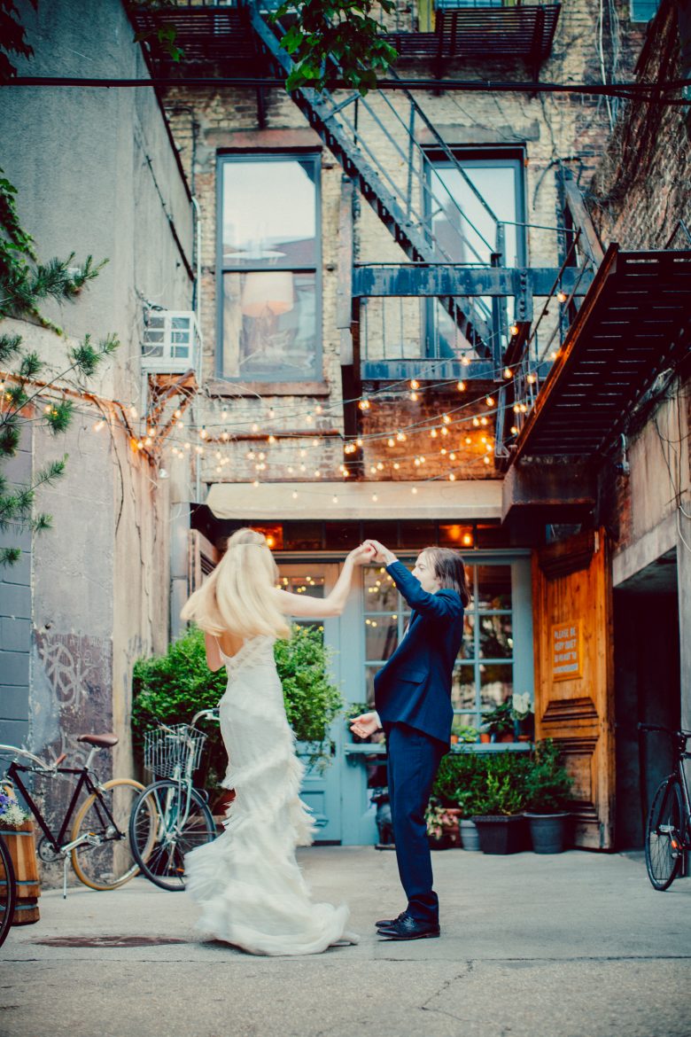 bride and groom dancing in alley