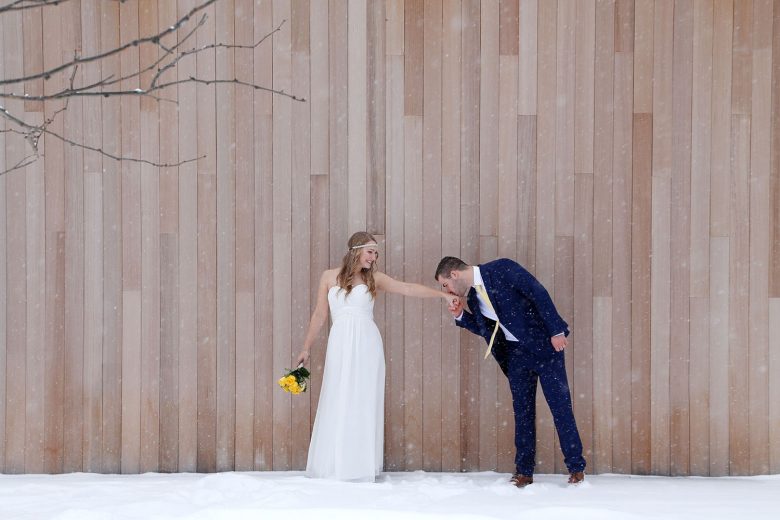 bride and groom in front of birch wood wall