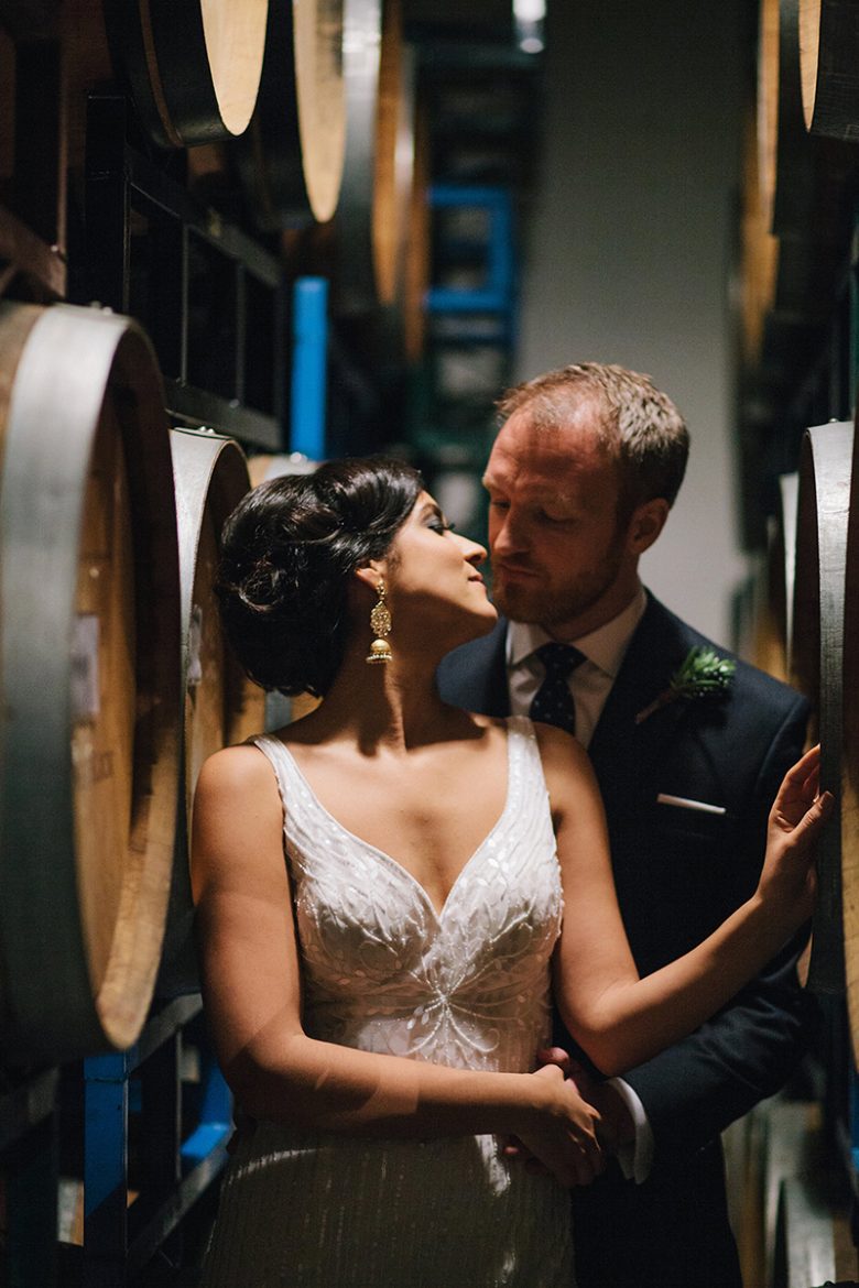 bride and groom with wine barrels