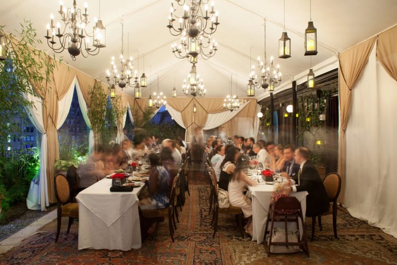 wedding dinner in a tent with chandeliers