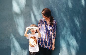 mother and son standing against a wall