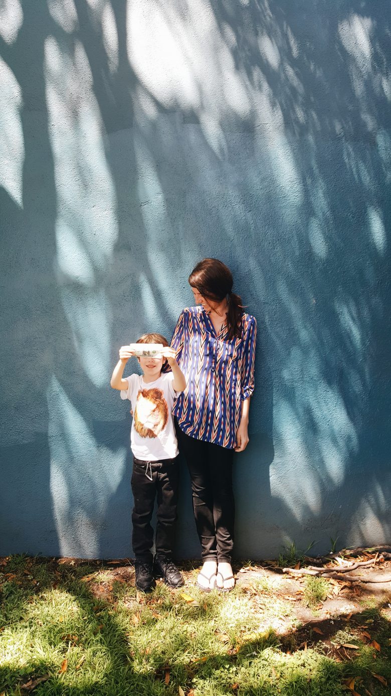 mother and son standing against a wall