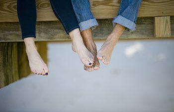 man and woman with feet touching