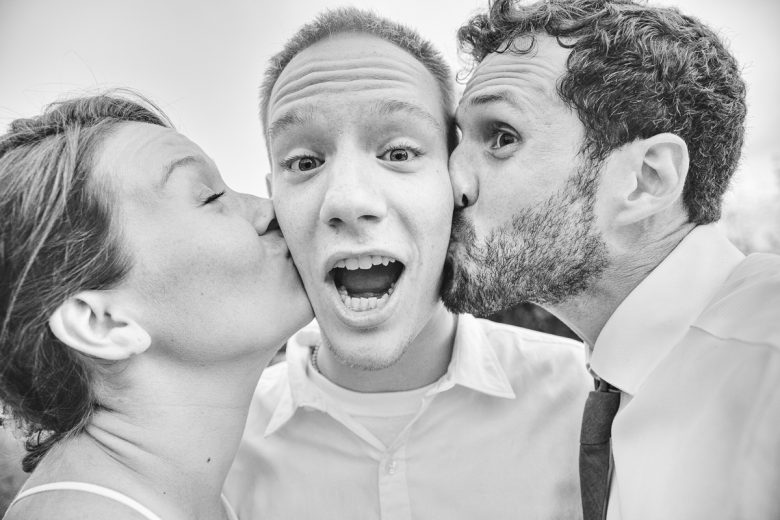 couple kissing friend on the cheek