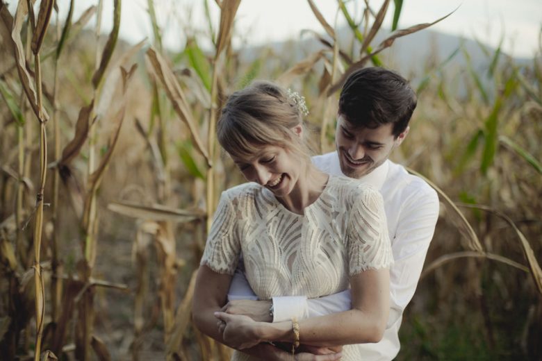 bride and groom embracing in a cornfield