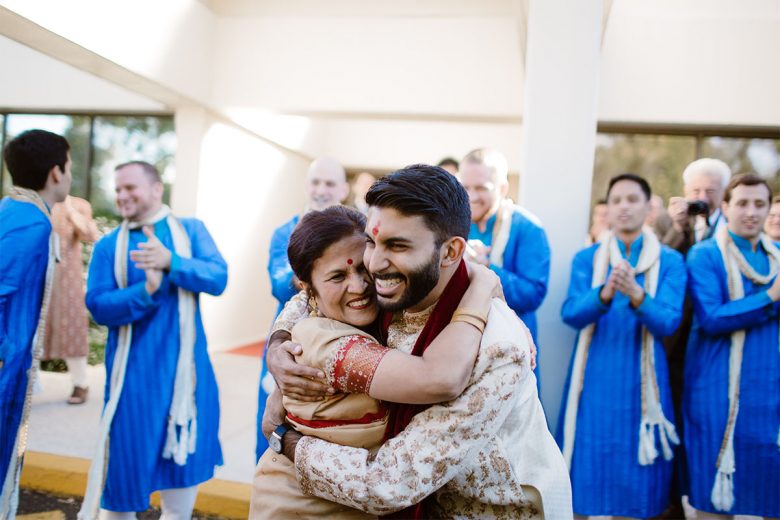 Indian groom hugging mother