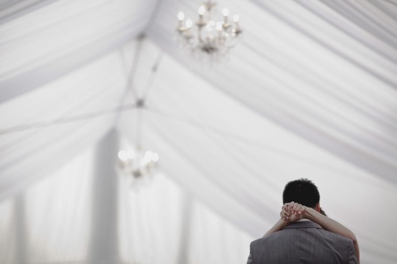 couple embracing under wedding tent