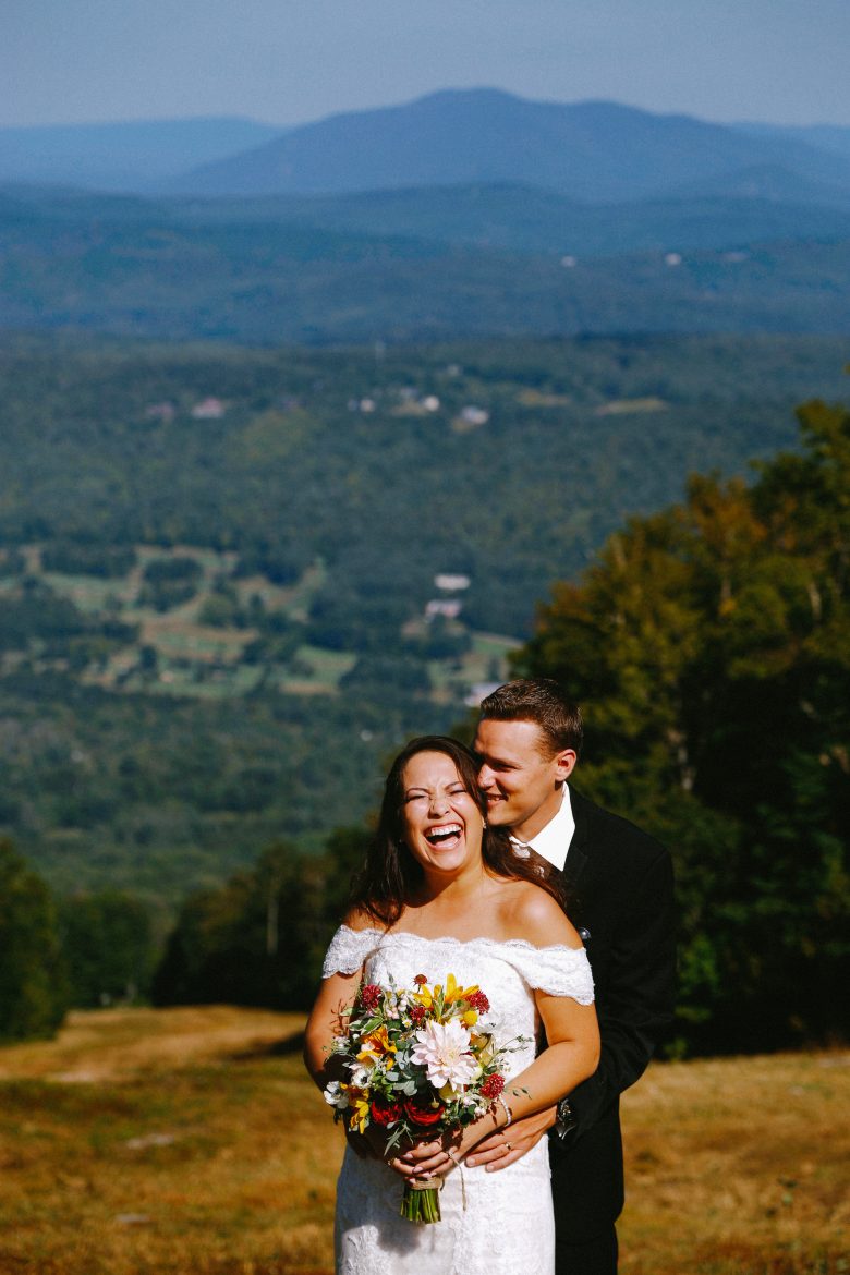 smiling bride and groom on mountaintop