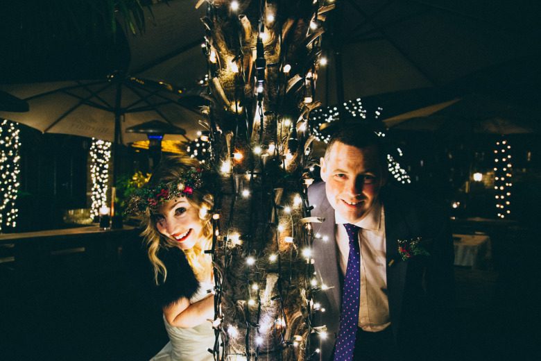 bride and groom with christmas lights