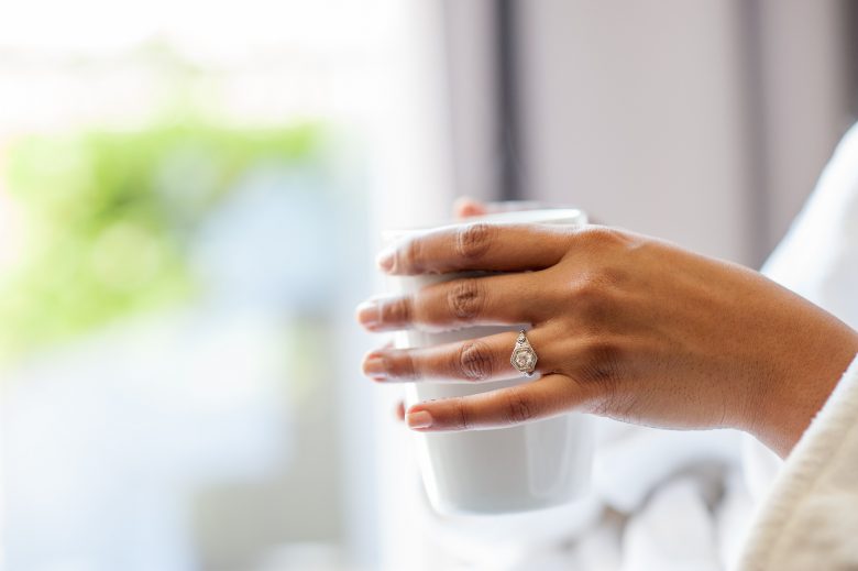 woman holding mug with engagement ring