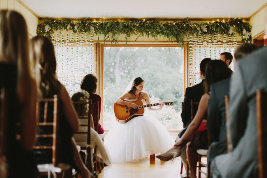 Bride playing guitar during her wedding ceremony