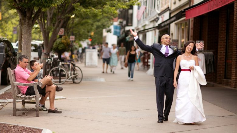 bride and groom walking down city street