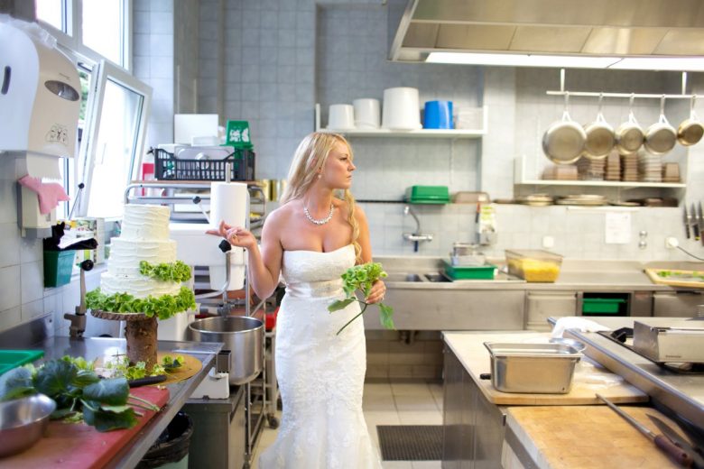 bride in kitchen with cake and flowers