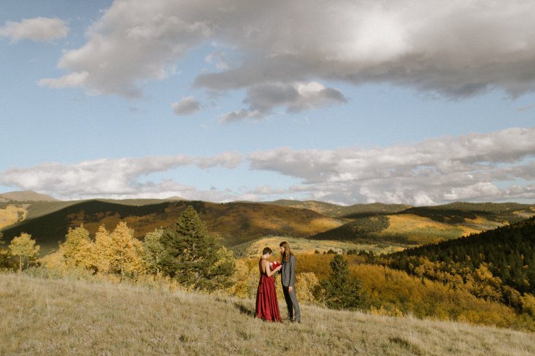 bride in a red dress eloping in the middle of a field