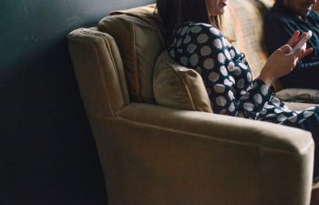 woman sitting on couch and looking at her phone