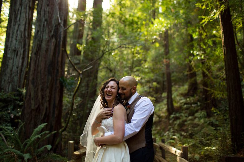 bride and groom laughing together in the forest