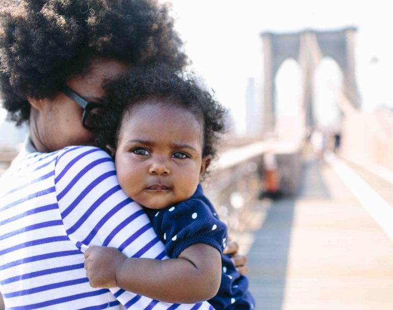 parent holding baby on a bridge