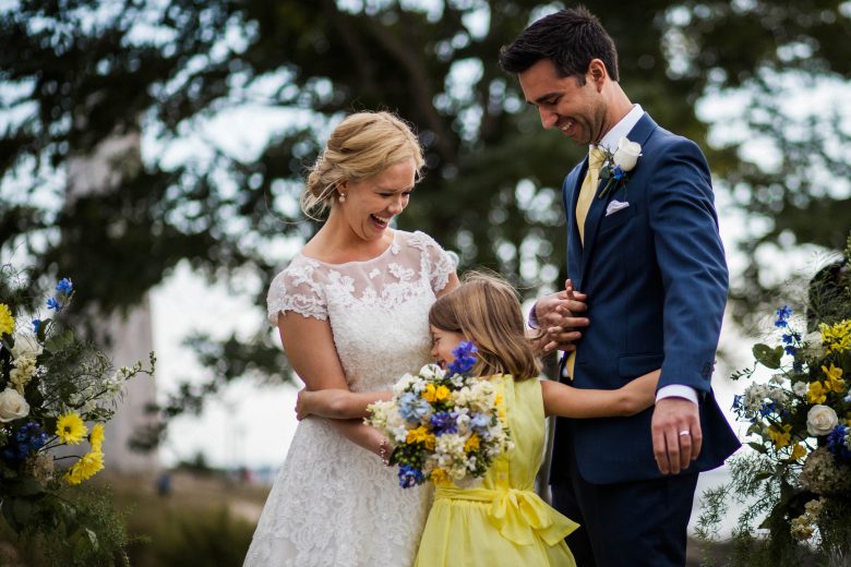 bride and groom laughing with young girl