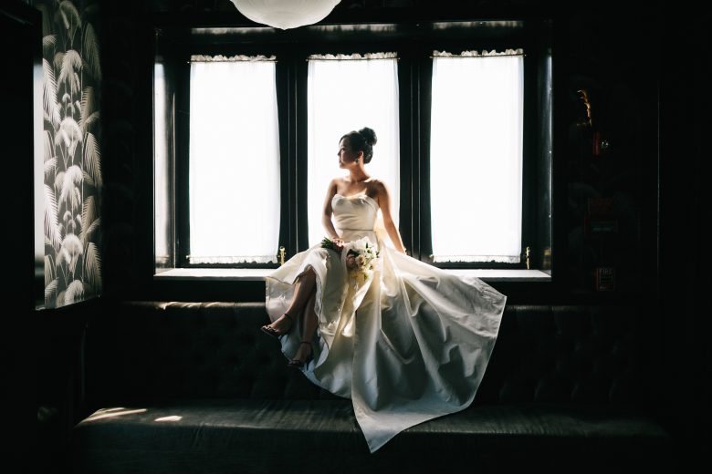 bride sitting alone in a window