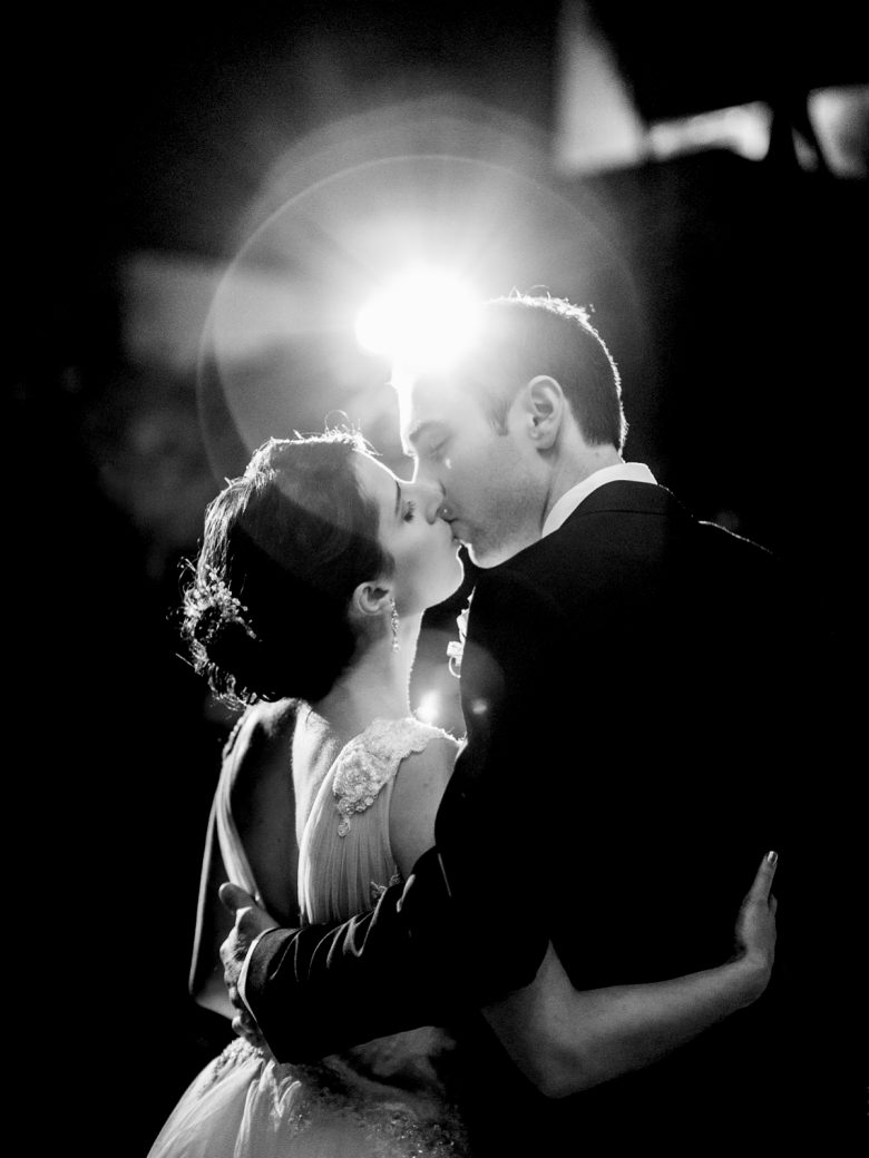bride and groom kissing under light