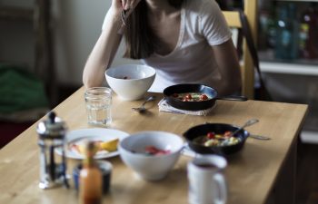woman eating breakfast alone