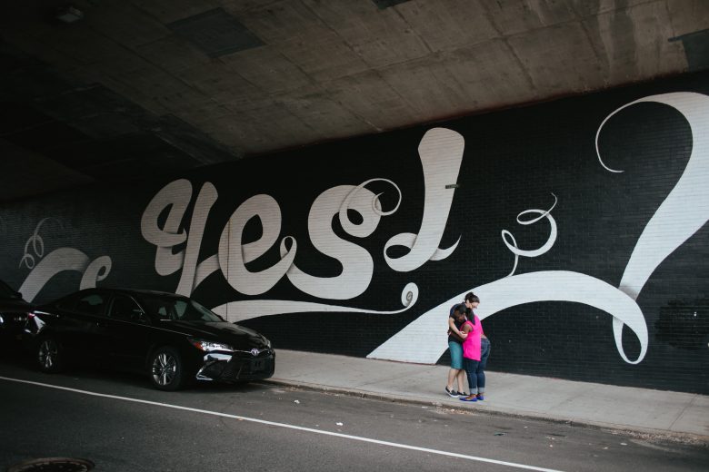 couple in front of yes mural after executing a great proposal idea