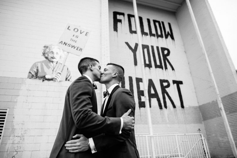 black and white photo of two grooms kissing