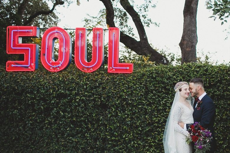 bride and groom in front of a SOUL sign