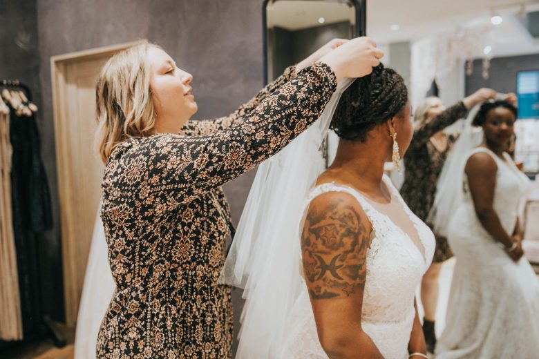 BHLDN stylist putting a veil on a black bride at the Palo Alto salon