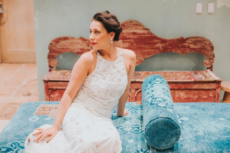 bride wearing BHLDN starling gown on a blue velvet anthropologie sofa