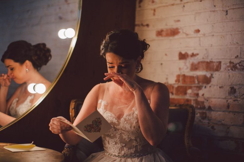 bride crying while reading a letter by evangeline lane