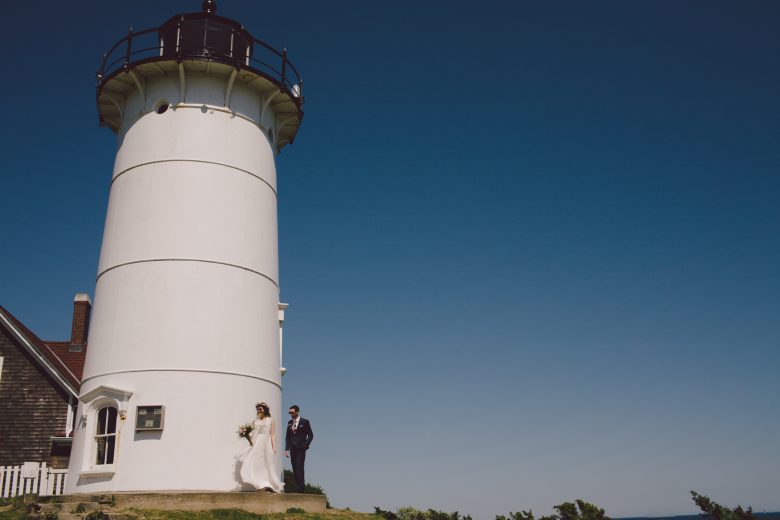 bride and groom next to a lighthouse