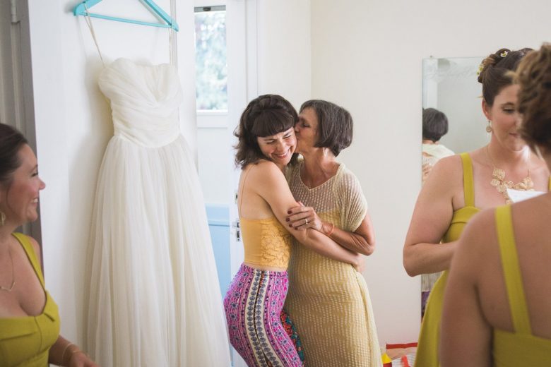 a mother kissing her daughter on her wedding day