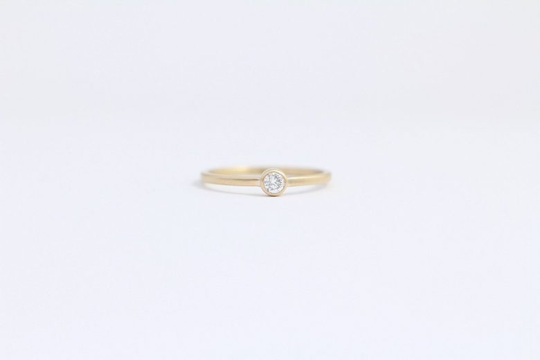 wedding ring from ash hilton with a gold band and round solitaire diamond