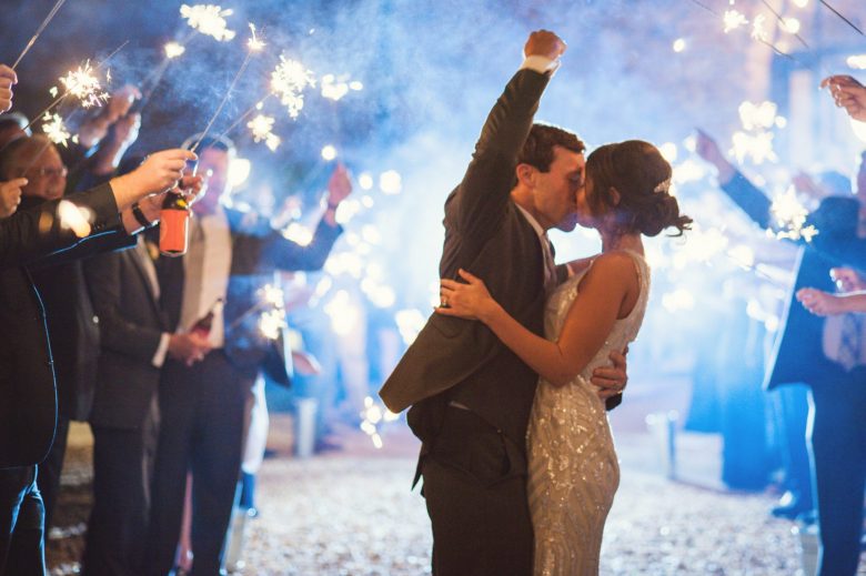 a couple kissing during a sparkler exit 