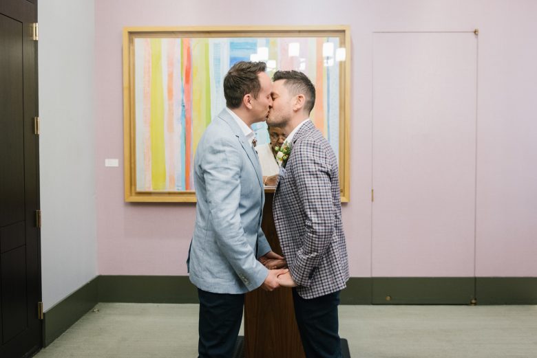 two grooms kissing at new york city hall wedding ceremony